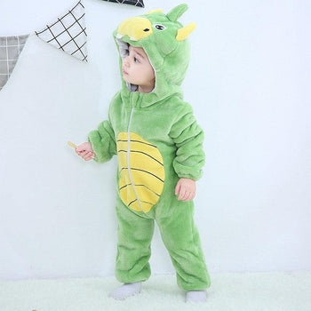 Jeune enfant debout portant un pyjama vert dragon