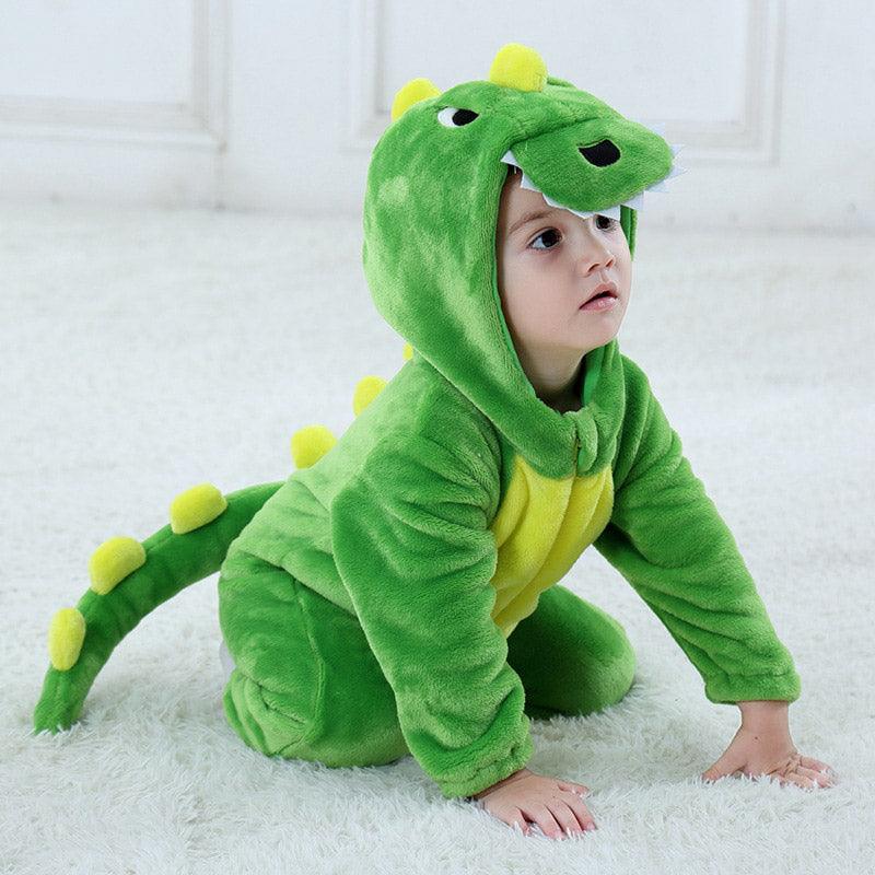 Enfant assis à genoux portant un pyjama vert dragon