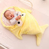 Sac de couchage en forme de requin jaune avec bébé souriant dedans pour le tenir au chaud